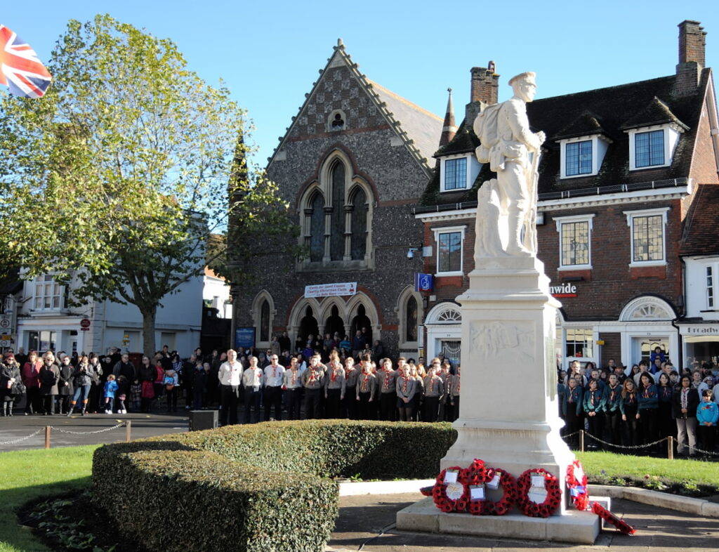 A view of uniformed groups gathered around the war memorial, which has been laid with wreaths.